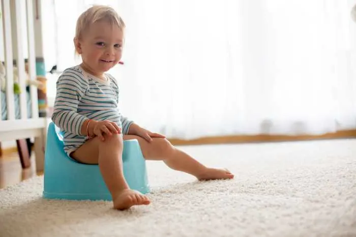 toddler sitting on blue potty chair