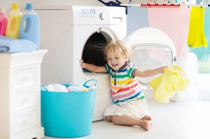 toddler pulling clothes out of a dryer