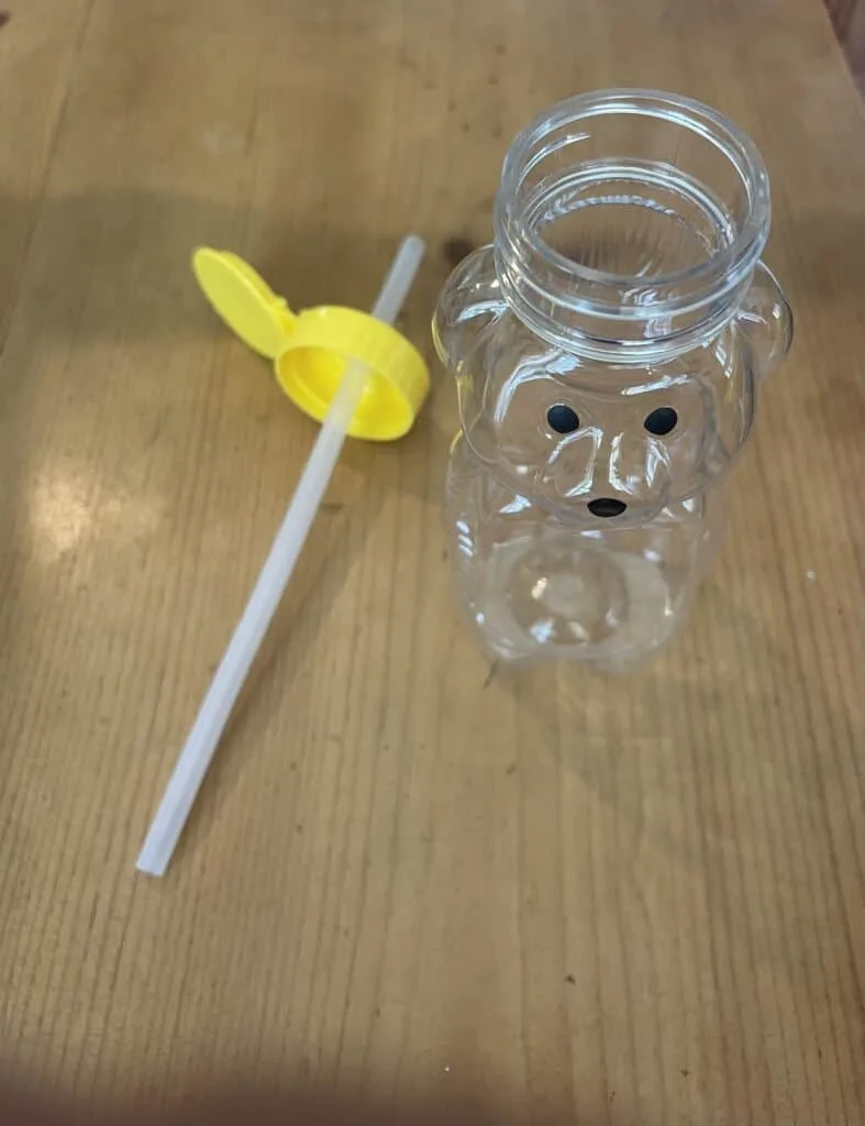 overhead view of honey bear cup with straw sitting next to it