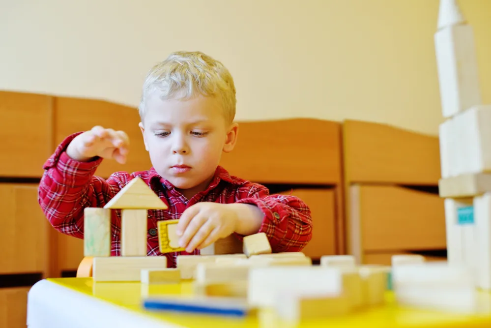 Toddler playing with wooden blocks