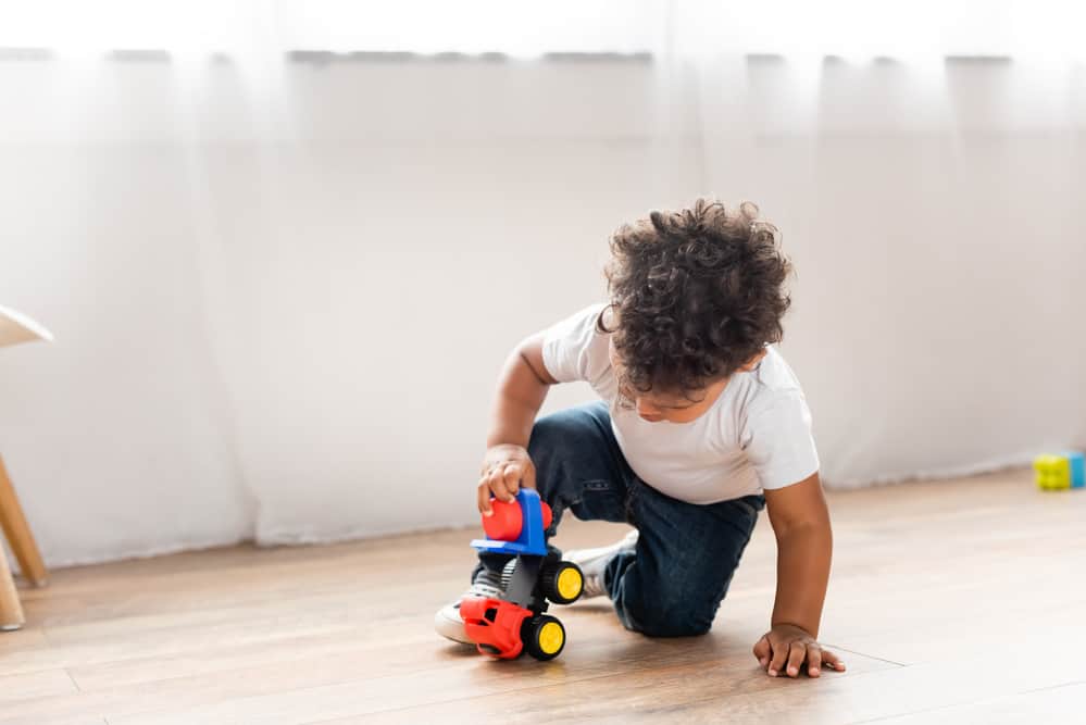 Child playing with a car on their own